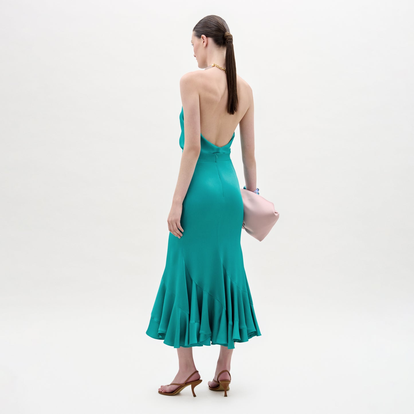 Woman wearing a teal dress with a white background