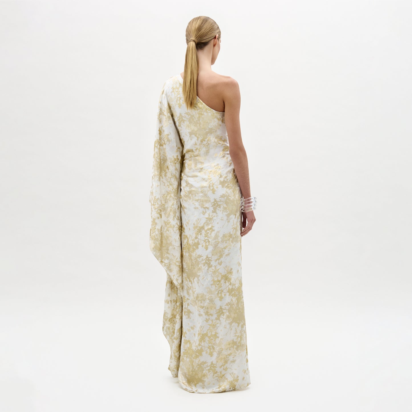 Woman wearing a floral one-shoulder dress on a white background