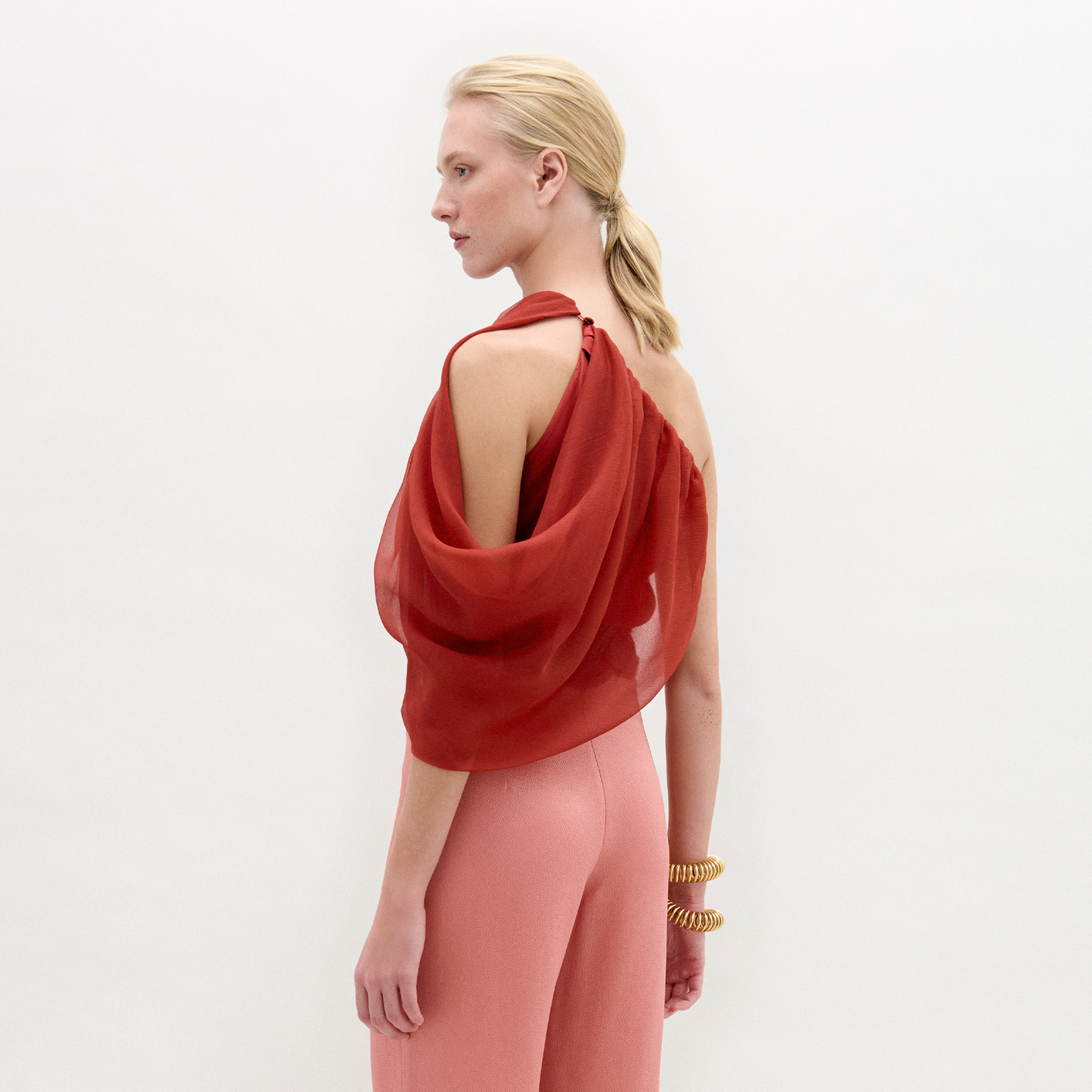 A person stands against a plain background wearing the Adil blouse