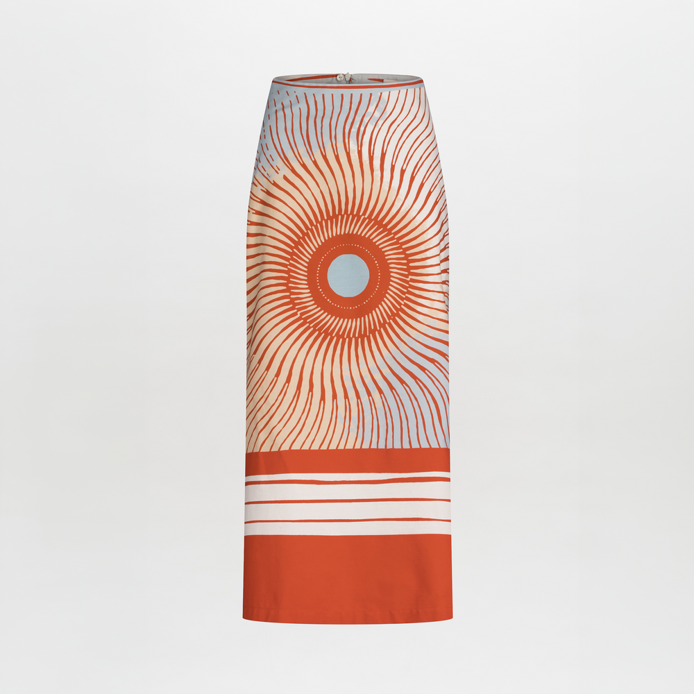The Atira Skirt by SVT DESIGNS is a high-waisted, 100% cotton midi skirt featuring a multicolor abstract sunburst print with bold horizontal white stripes near the hem on a plain background.