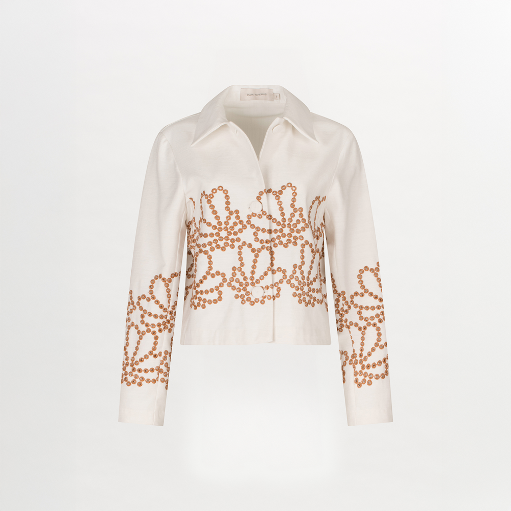 The Belen Jacket by Silvia Tcherassi US is a long-sleeve, collared white blouse with a straight cut and intricate brown beaded circular patterns on the chest, sleeves, and hem. Expertly crafted in Colombia and shown on a plain white background.