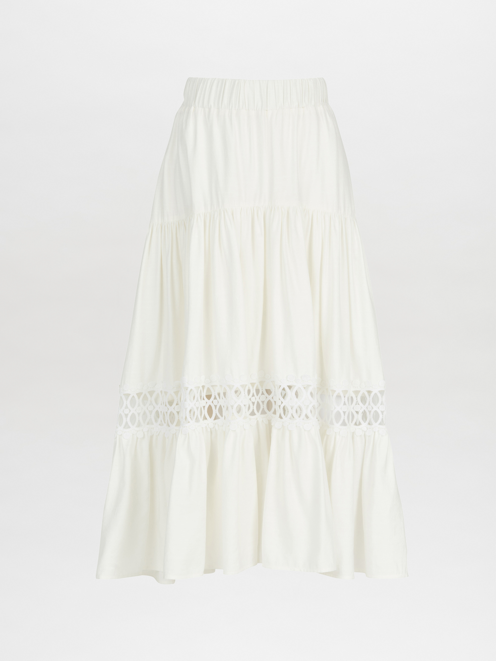 The Cher Skirt White by SVT Designs is an ankle-length, white viscose skirt featuring a tiered design on a plain background, highlighted by its elastic waistband and a decorative lace trim panel in the middle for an added elegant flair.