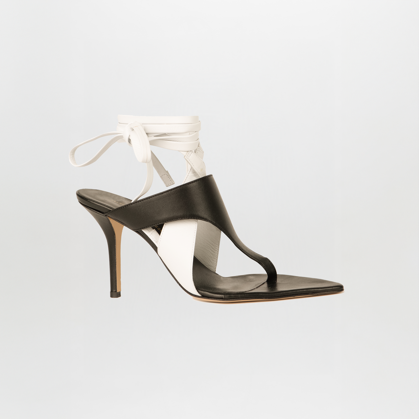 The Domenico Heels Black/White by SilviaTcherassi feature Italian leather in black and white, an open toe, thong strap, and ankle wrap tie—an elegant sandal shown against a plain light background.
