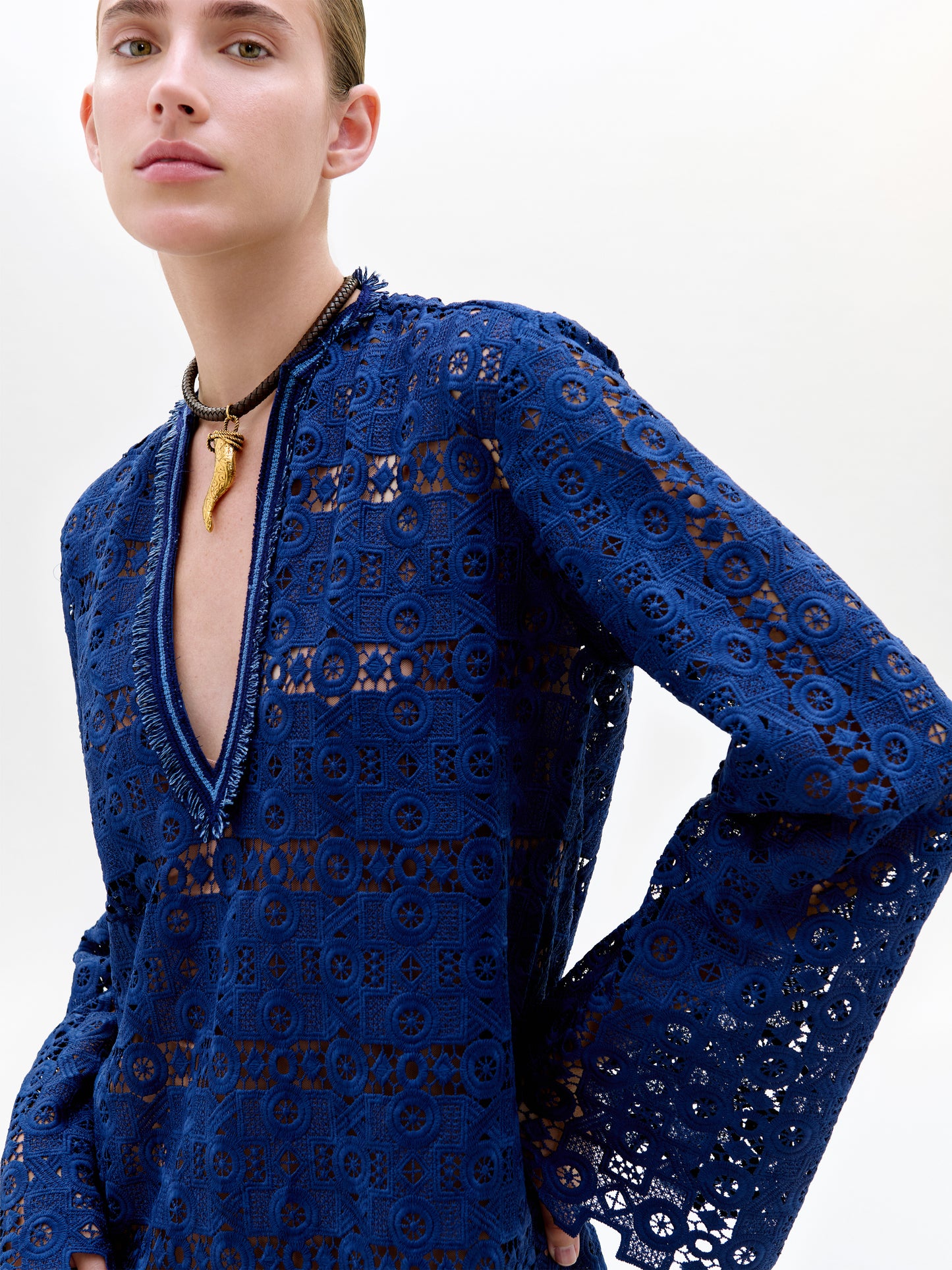 Woman wearing a blue lace dress with a white background