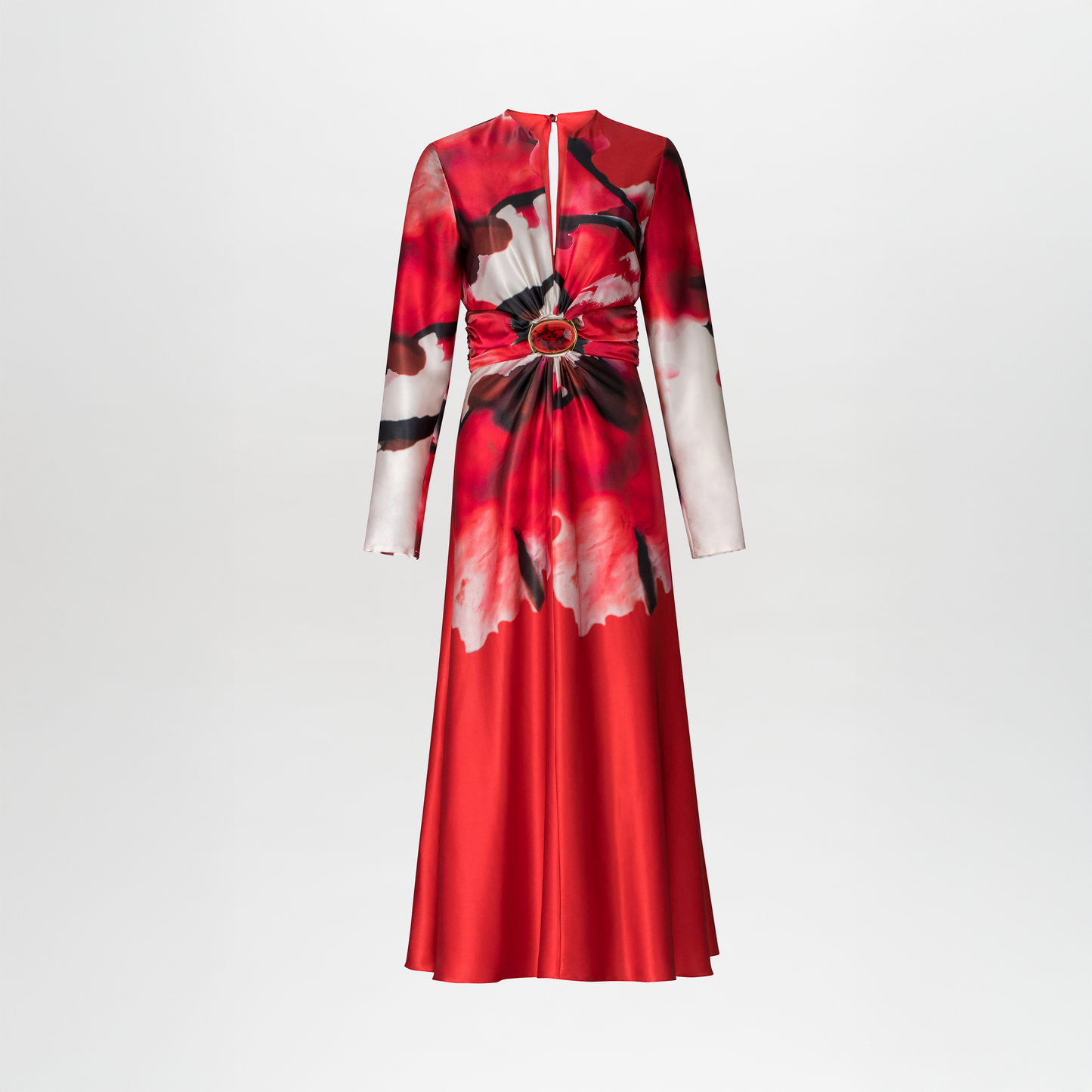 The Katarina Dress by SVT DESIGNS is a long-sleeved, floor-length silk dress with bold red, black, and white abstract floral print, a cinched waist with gathered fabric, and a central decorative ring, shown on a plain white background.