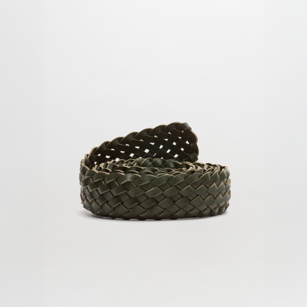 The Lauren Belt by SVT DESIGNS is a woven dark green braided Italian leather belt, coiled on a plain white background. It features a detailed braided pattern and no visible buckle.