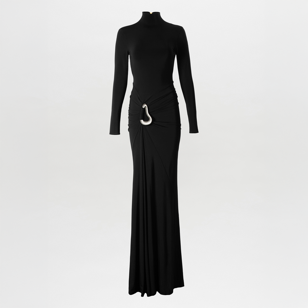 The Lena Dress by SVT DESIGNS is a long black maxi dress with long sleeves, a high neckline, a fitted silhouette, and an asymmetric waistline gathered at the side and finished with a statement metallic buckle.