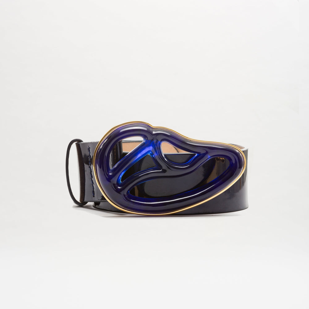 The SVT DESIGNS Nala Belt features black Italian leather and a large, abstract Petralux buckle in metallic blue and gold, pictured on a plain white background.