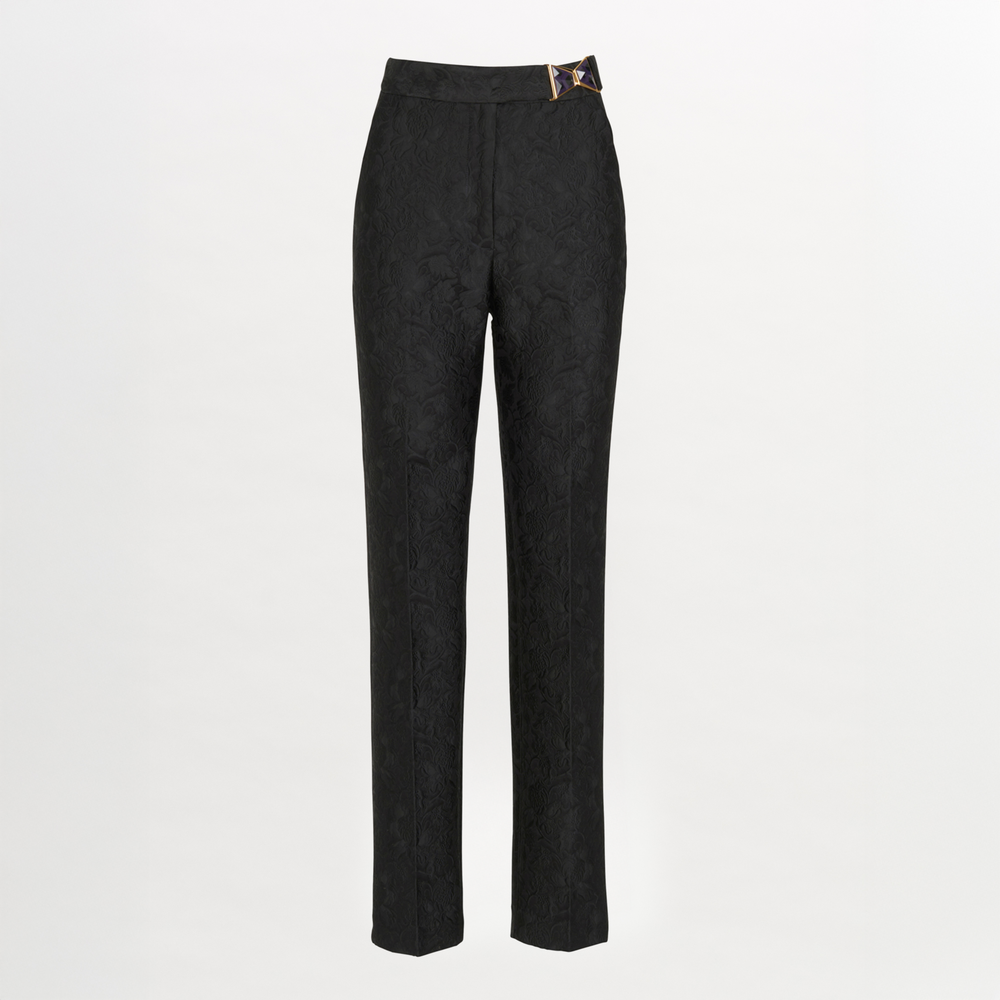 The Orion Pant Black by Silvia Tcherassi features a high waist, subtle floral pattern, straight leg cut, and a gold rectangular buckle detail at the waistband, shown against a plain white background.