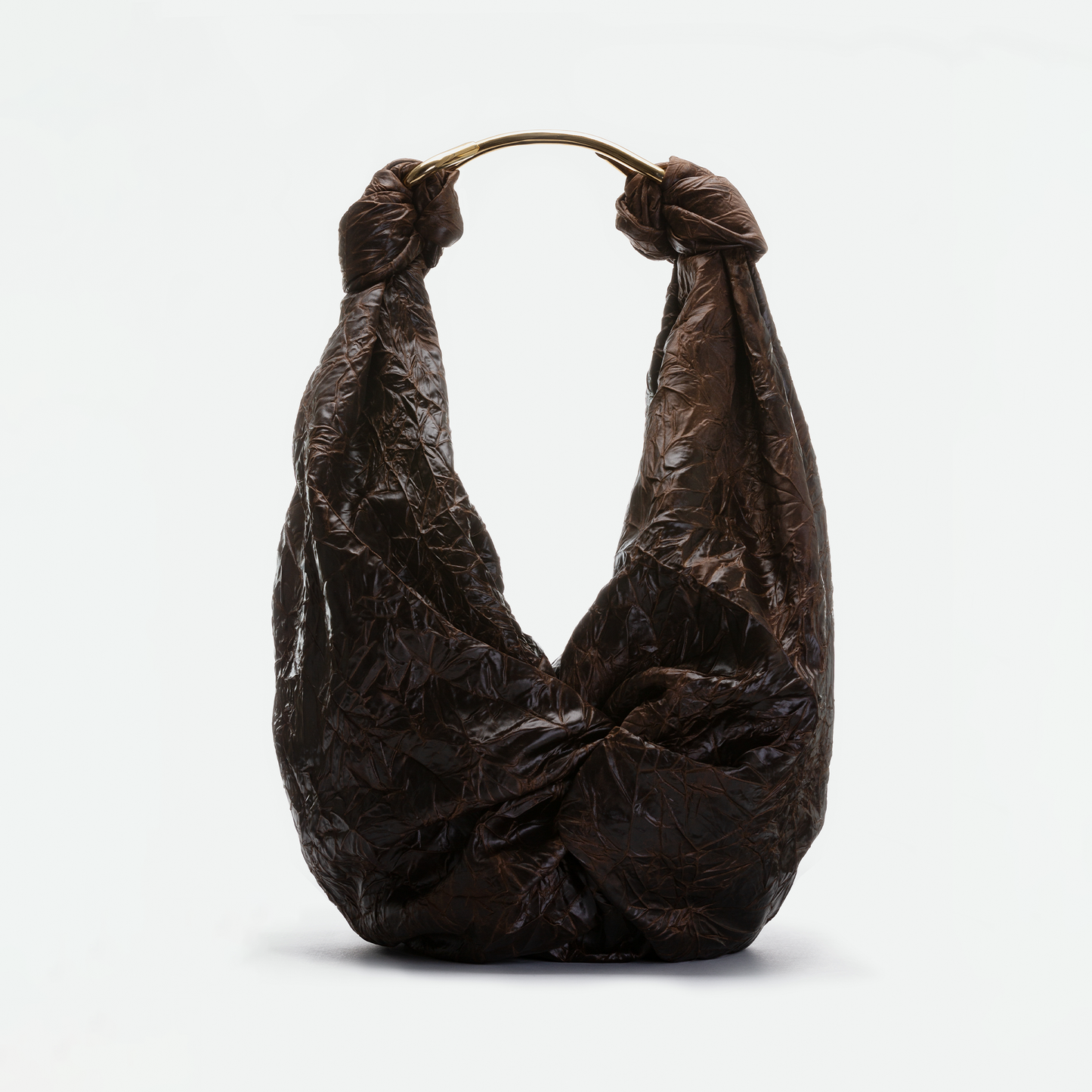 The SVT DESIGNS Sofia Bag (Maxi), featuring a brown crinkled finish, slouchy silhouette, and gold-toned curved handle, is shown against a plain white background.