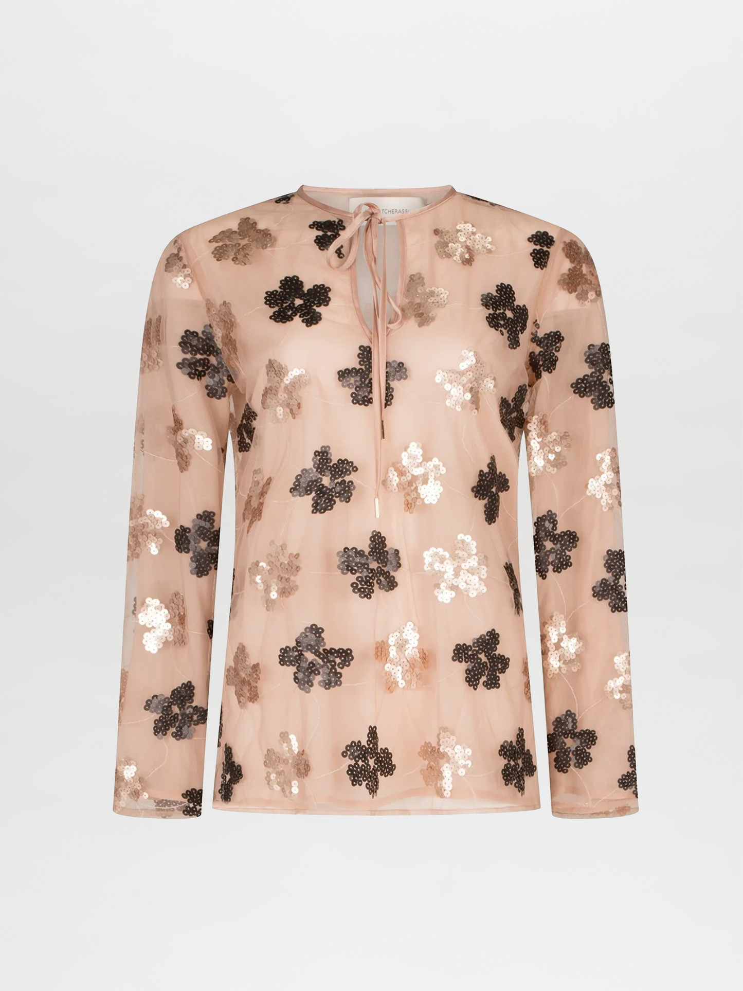 The Tosca Blouse by Silvia Tcherassi US is a sheer, long-sleeve top in light beige with a keyhole neckline, front tie, and metallic sequin floral designs.