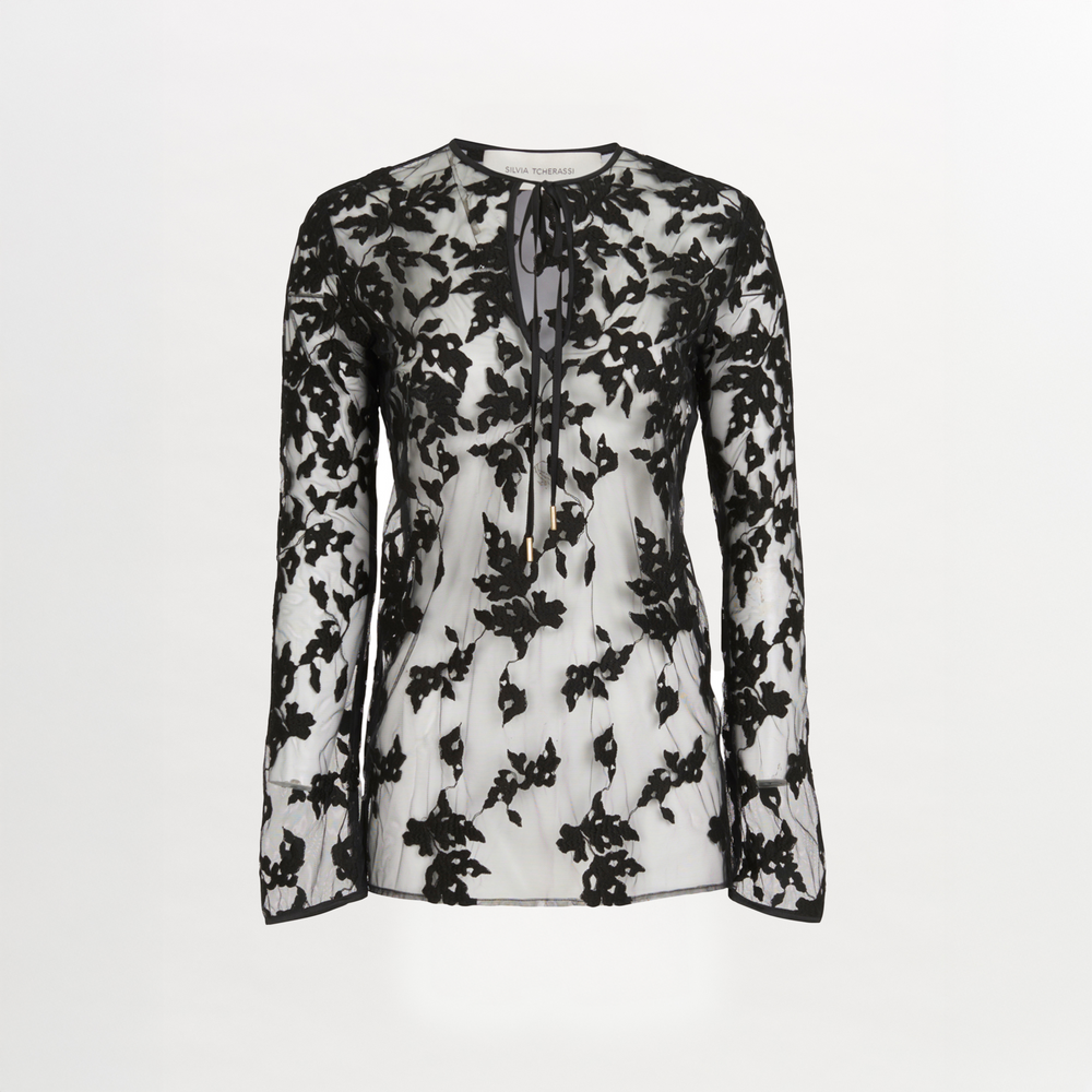 The Tosca Blouse Black Velvet by Silvia Tcherassi is a sheer silk blouse with black floral embroidery, a round neckline, keyhole opening, and neck tie, set against a plain white background.