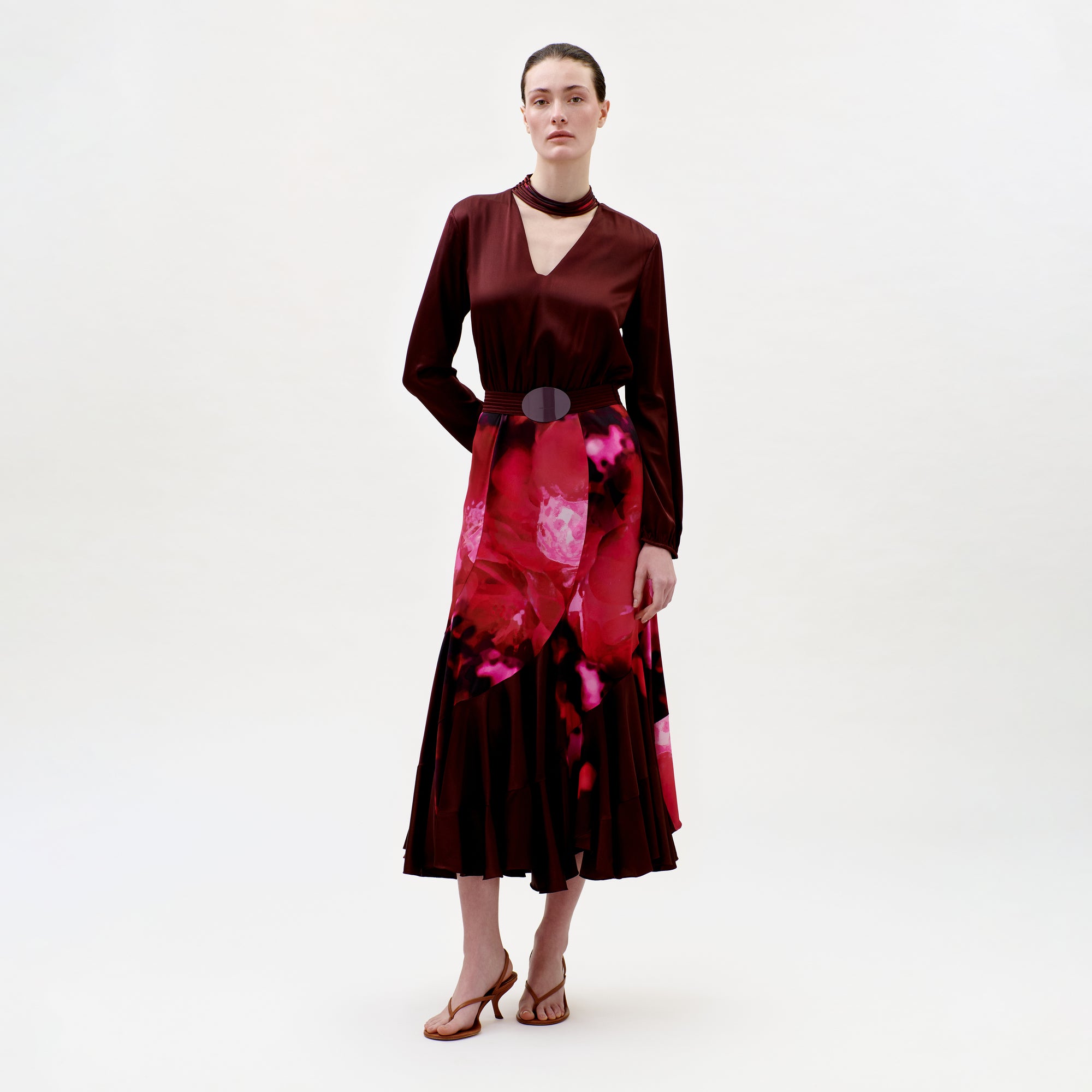 Woman wearing a burgundy dress with a floral pattern on a white background