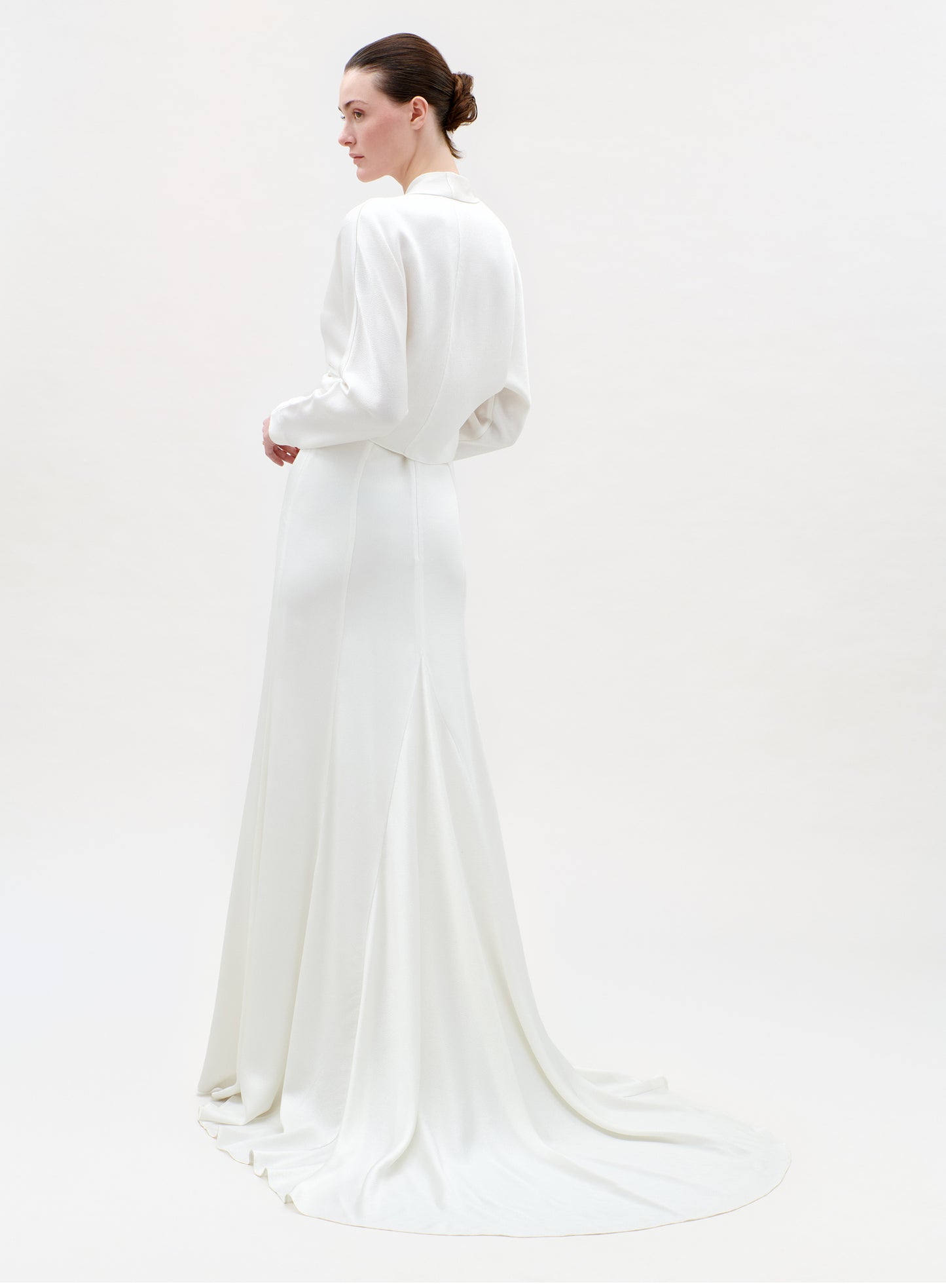 Woman wearing a white dress on a plain background