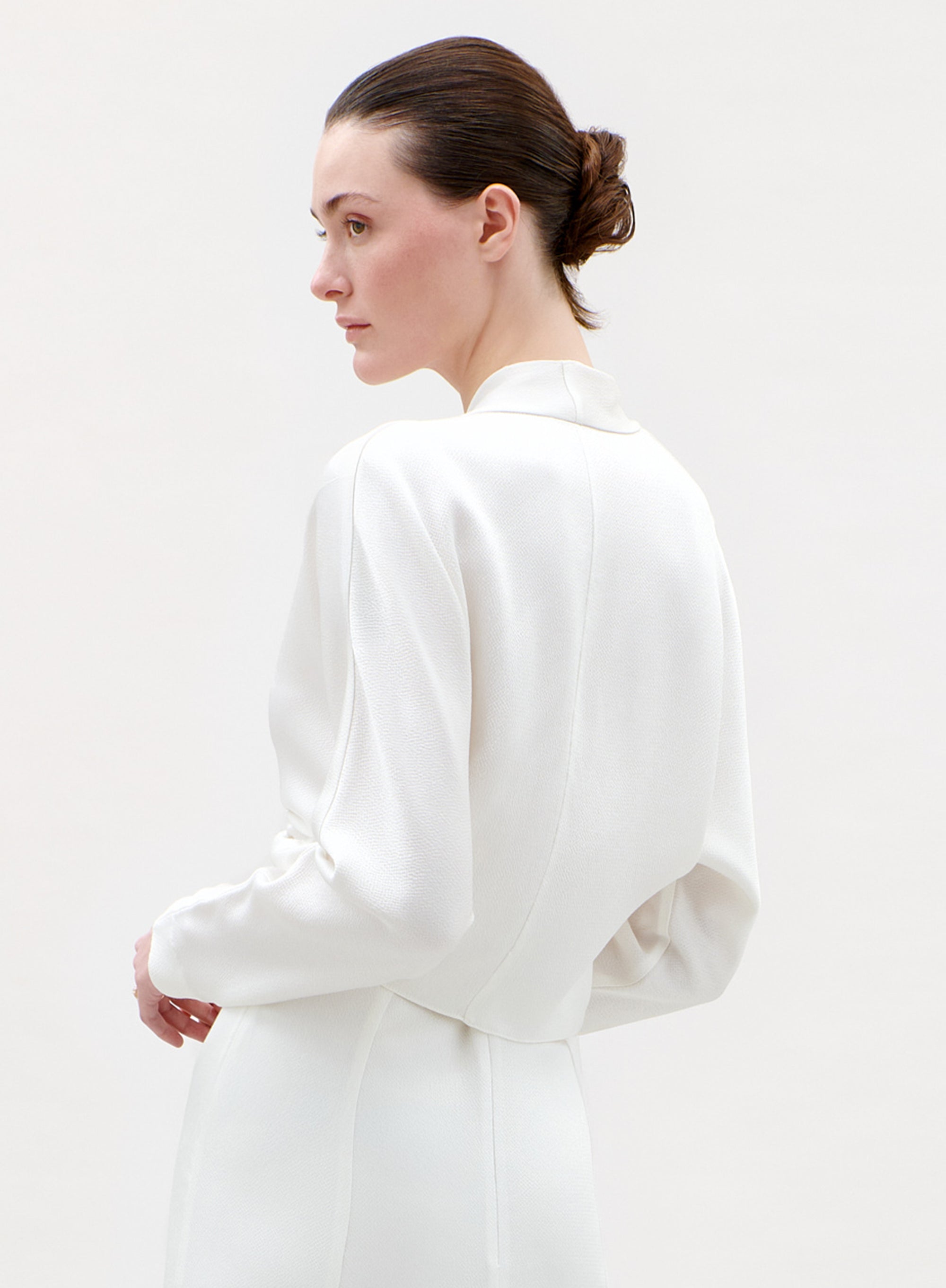 Woman wearing a white blouse against a plain background