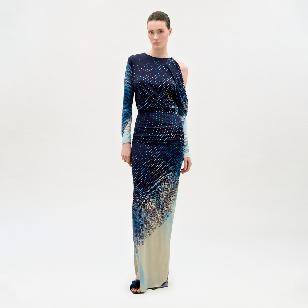 Woman wearing a long, patterned dress on a white background