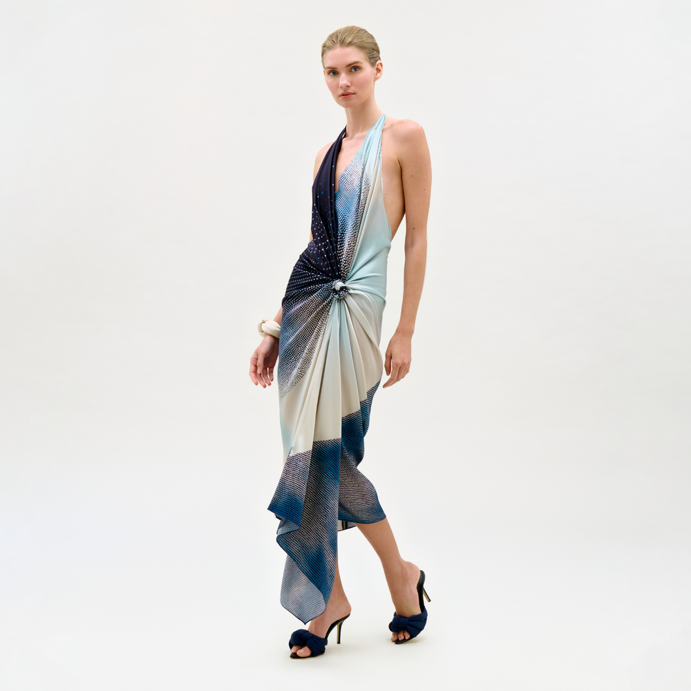 Woman wearing a patterned halter neck dress on a white background
