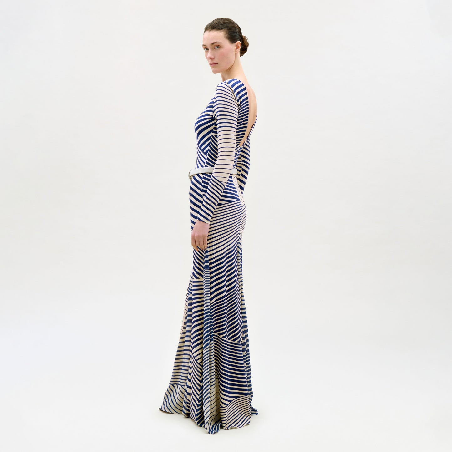 Woman wearing a long, striped dress on a white background