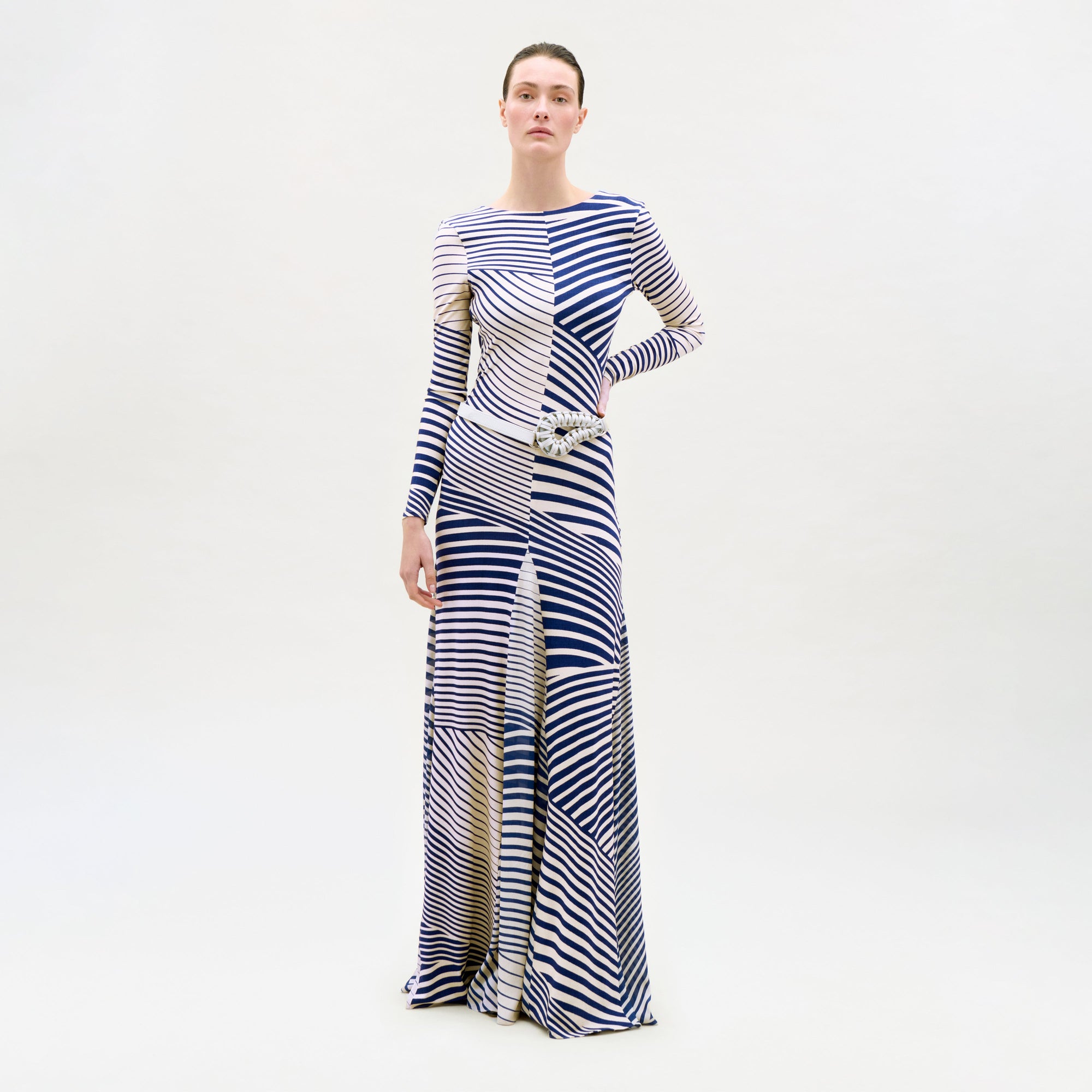Woman wearing a long, patterned dress on a white background