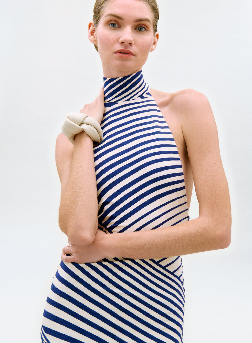 Woman wearing a blue and white striped dress against a plain background