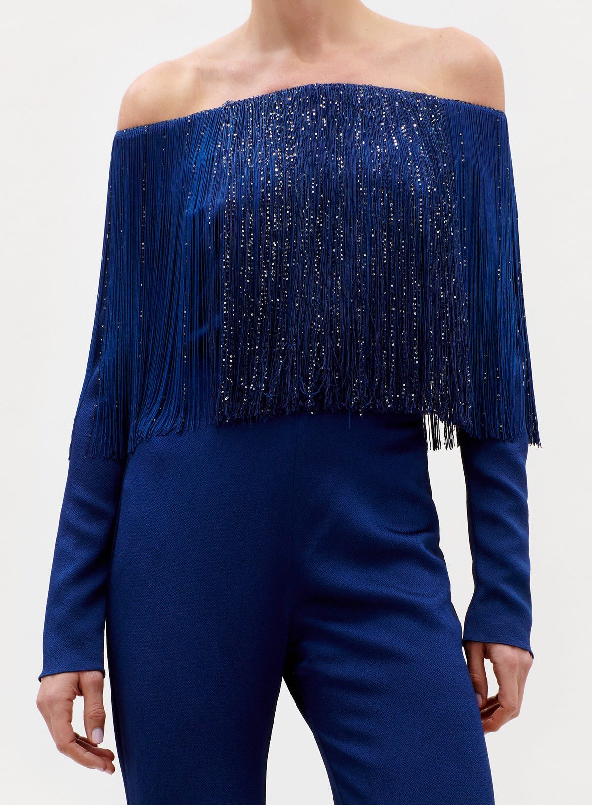 Blue off-shoulder top with fringe details on a white background