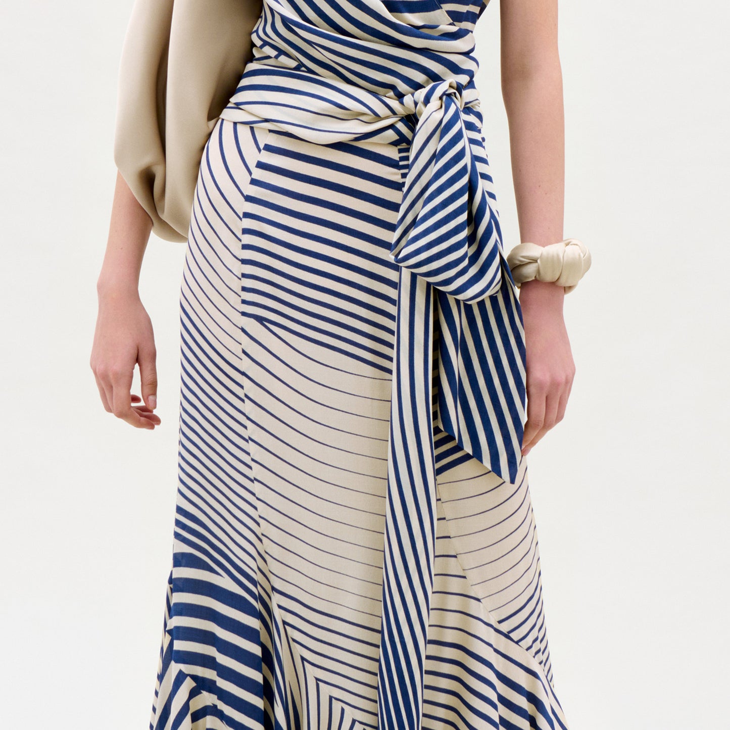 Woman wearing a blue and white striped dress with a plain background