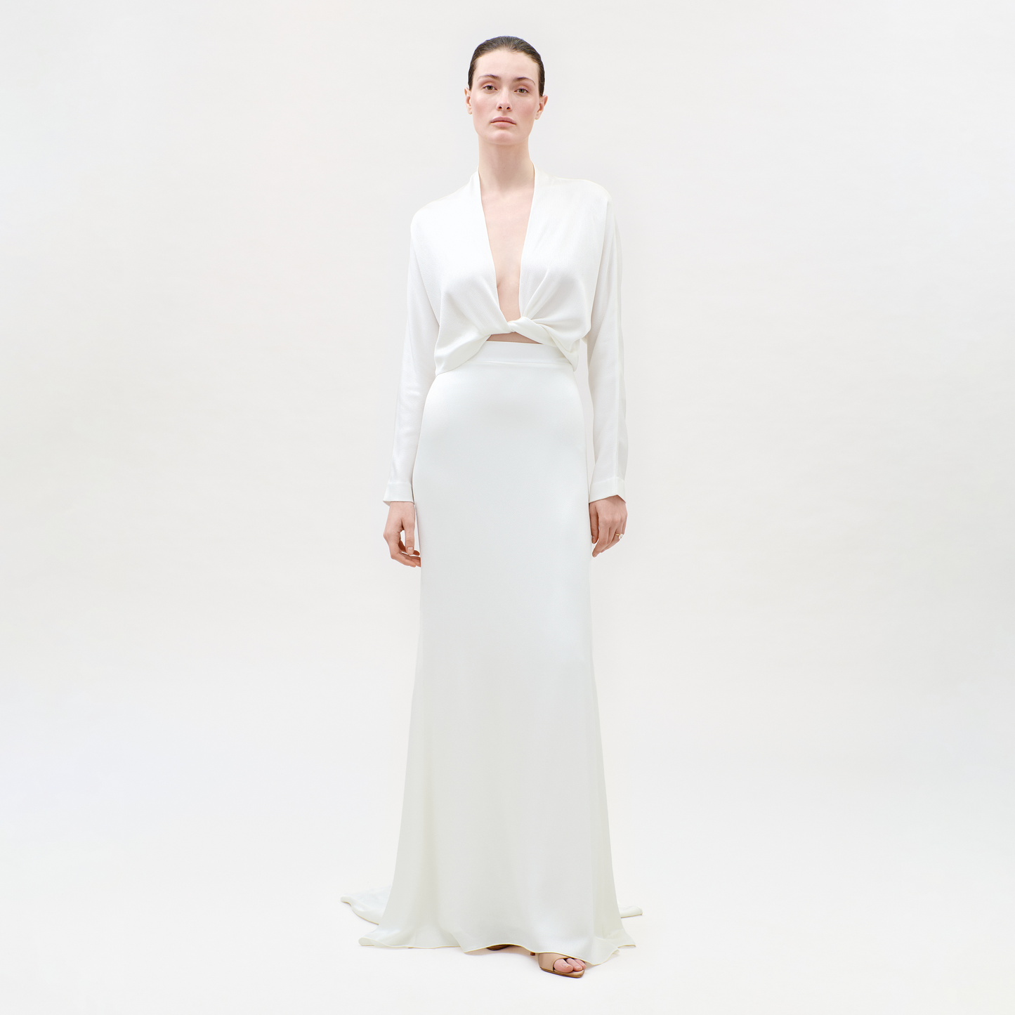 Woman wearing a white dress on a plain background