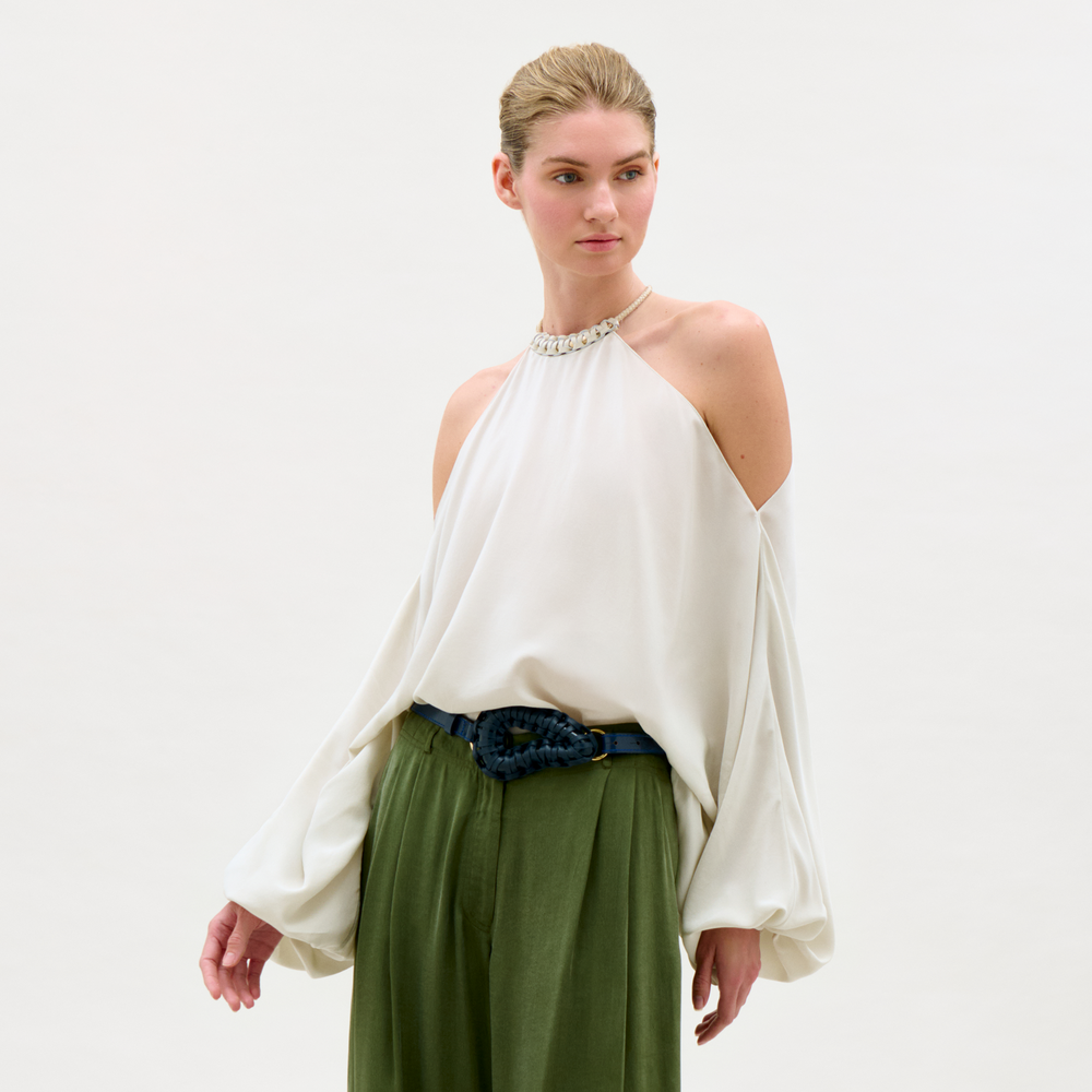 Woman wearing a white top and green skirt on a white background