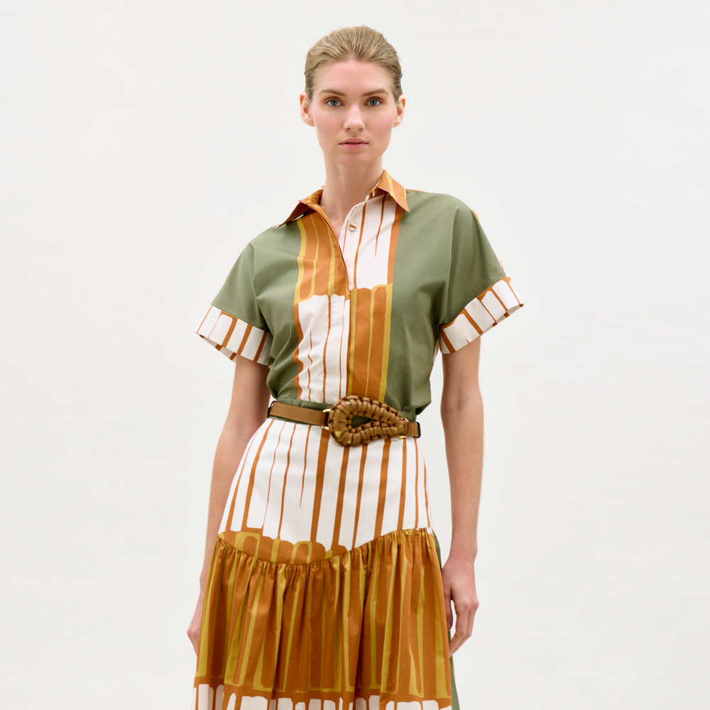 Woman wearing a green, orange, and white striped dress on a white background