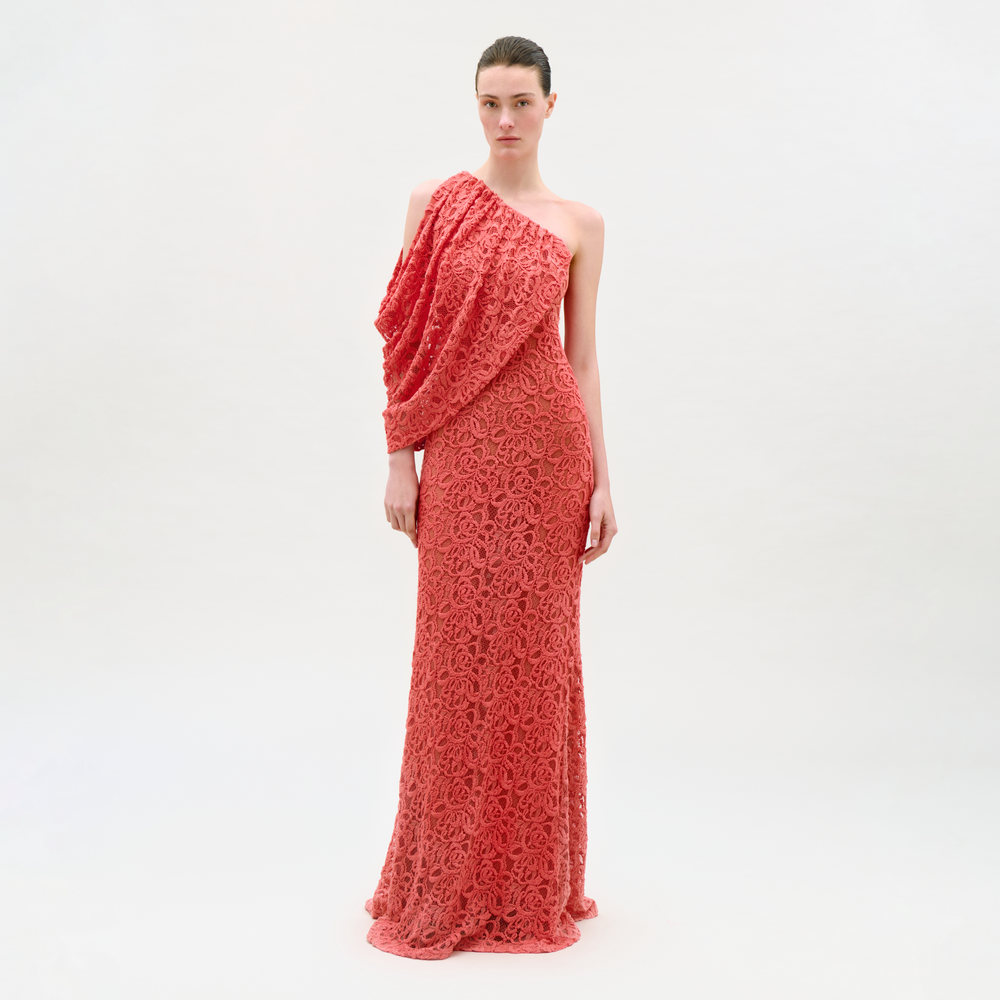 Woman wearing a coral one-shoulder dress on a white background