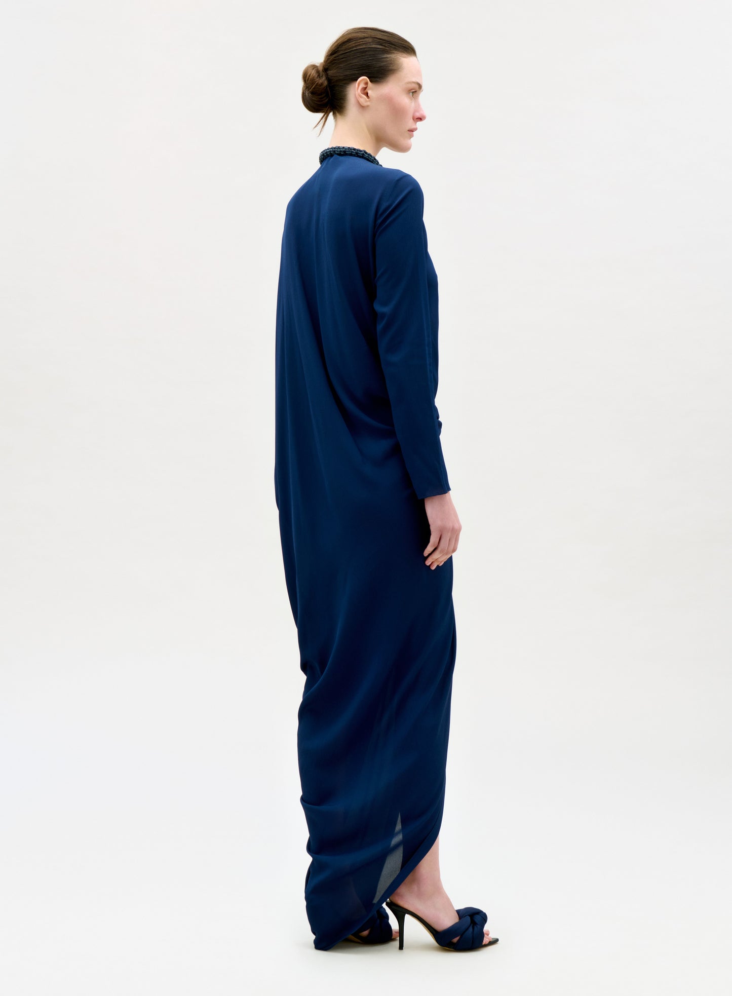 Woman wearing a long blue dress on a white background