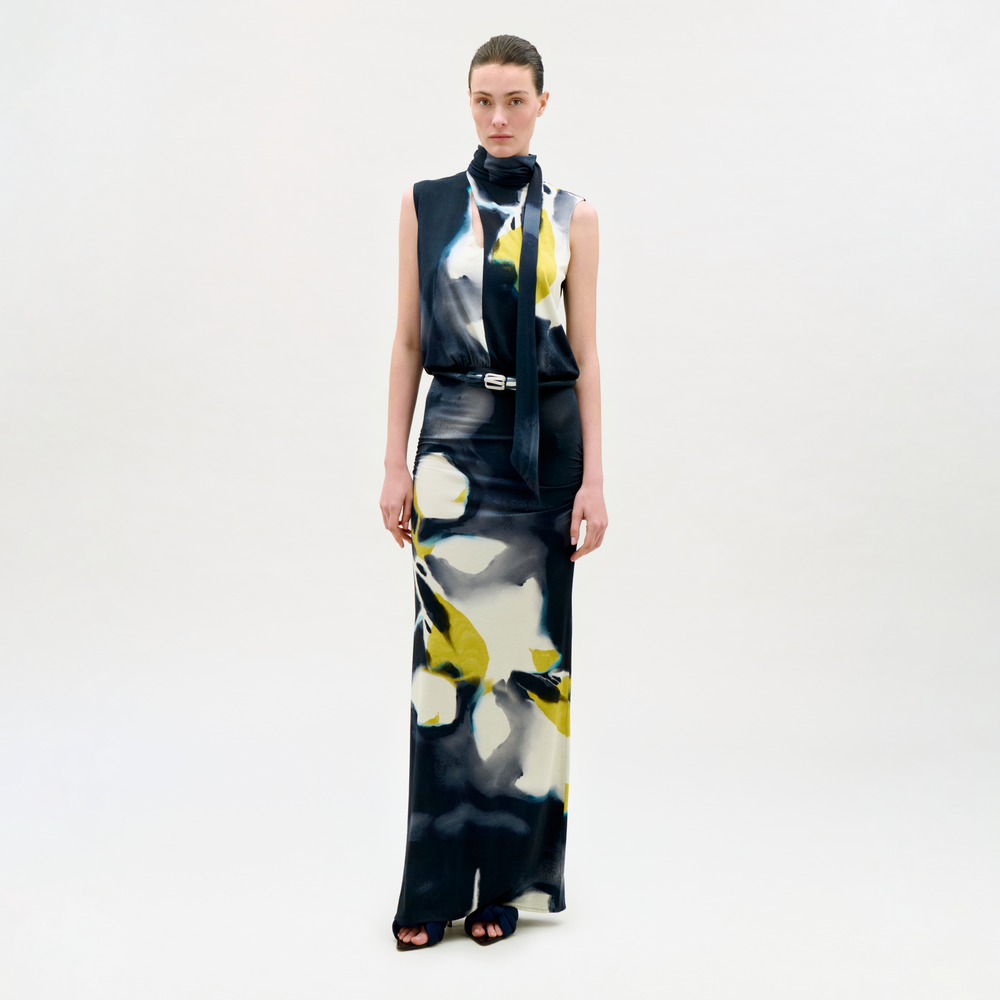 Model wearing a sleeveless dress with abstract floral pattern on a white background
