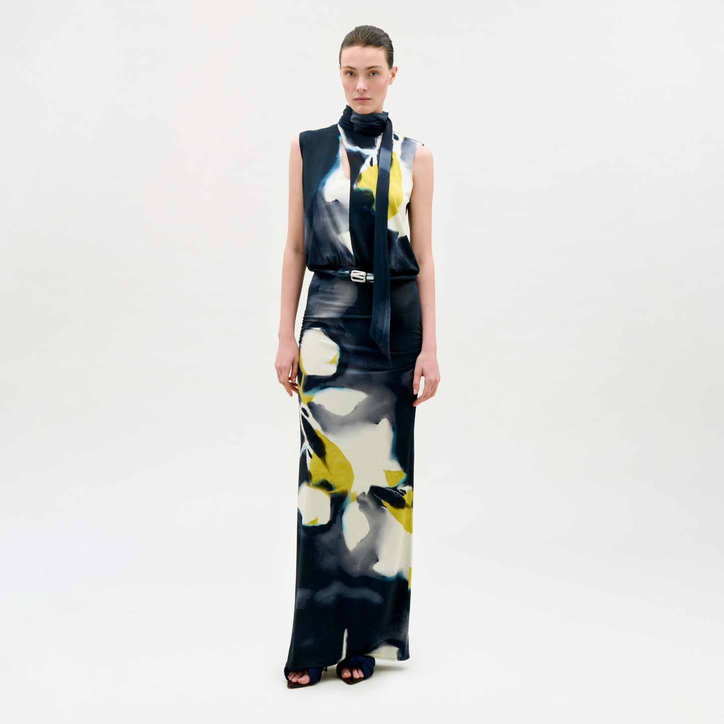 Model wearing a sleeveless dress with abstract floral pattern on a white background