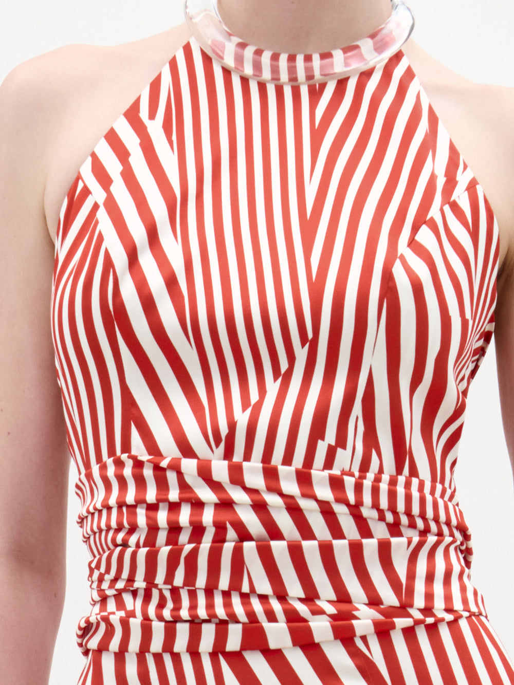 A person wears the Carmela Blouse by SVT DESIGNS, an Italian fabric crop top with red and white stripes, a high chunky collar detail, and sleeveless design; only the upper torso is visible.