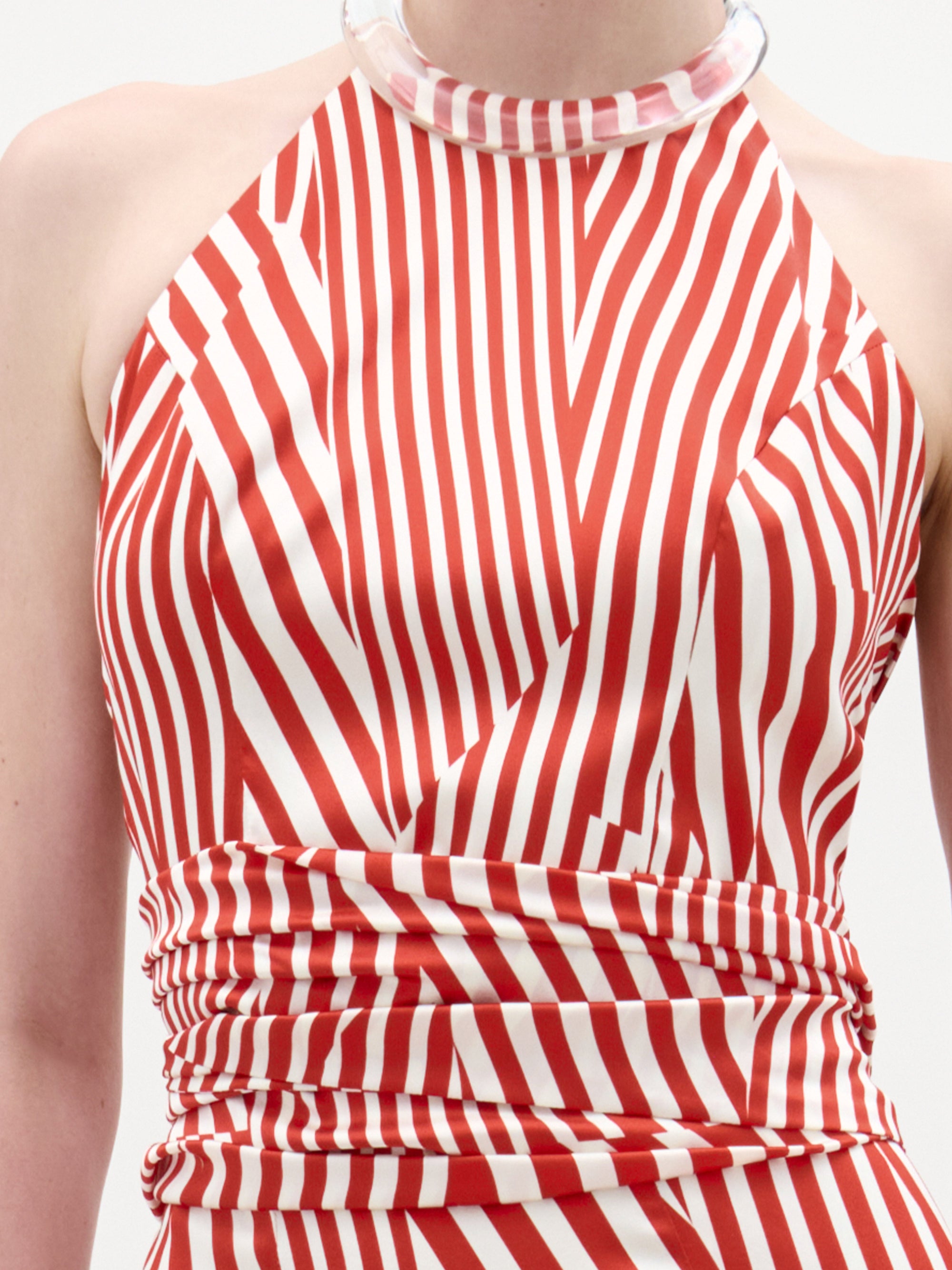 A person wears the Carmela Blouse by SVT DESIGNS, an Italian fabric crop top with red and white stripes, a high chunky collar detail, and sleeveless design; only the upper torso is visible.