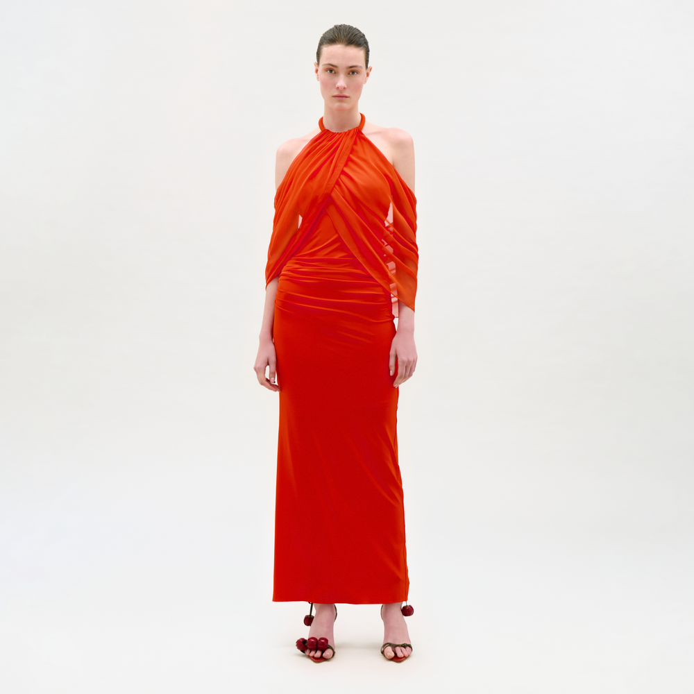 Woman wearing a red halter neck dress on a white background