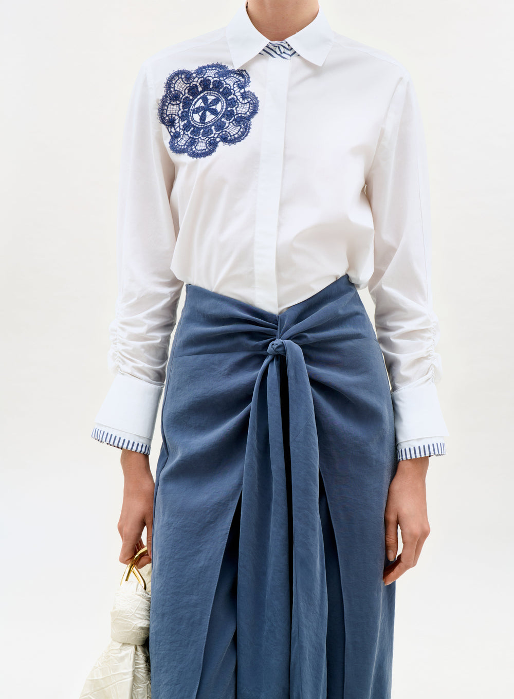 White shirt with blue embroidery and blue skirt on a white background