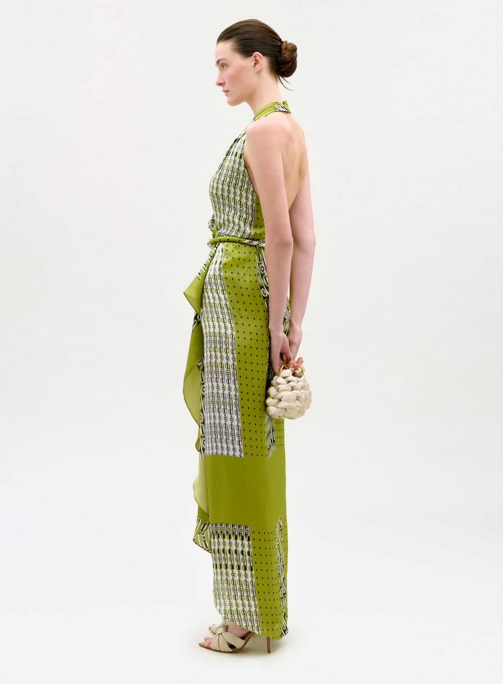 Woman wearing a green and white patterned dress on a white background