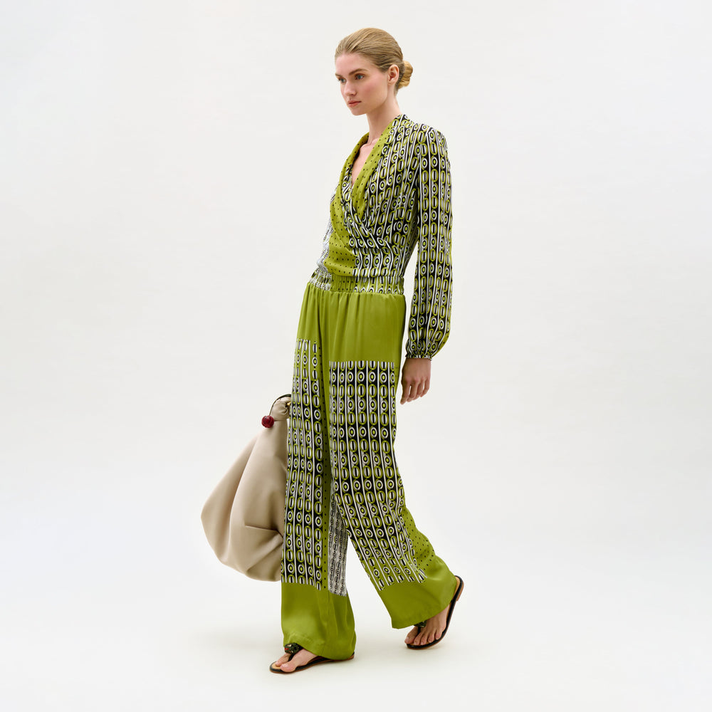 Woman wearing a green and patterned outfit on a white background