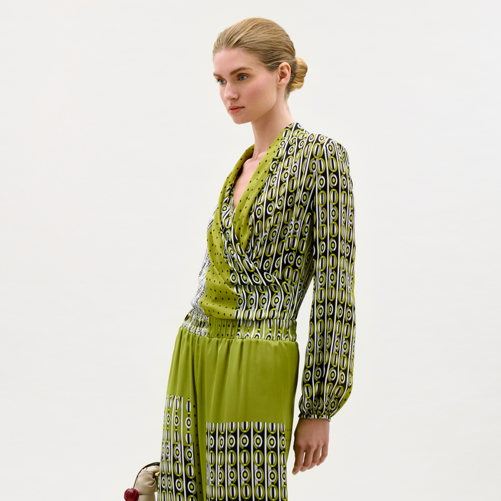 Woman wearing a green patterned dress on a white background