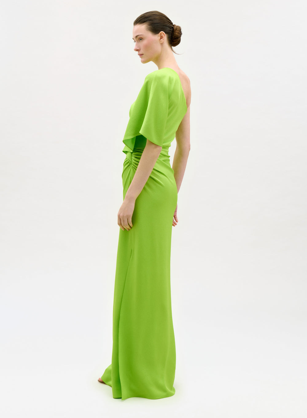 Woman wearing a bright green evening gown on a white background