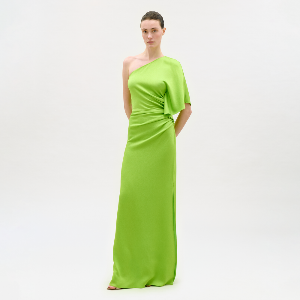 Woman wearing a bright green one-shoulder dress on a white background