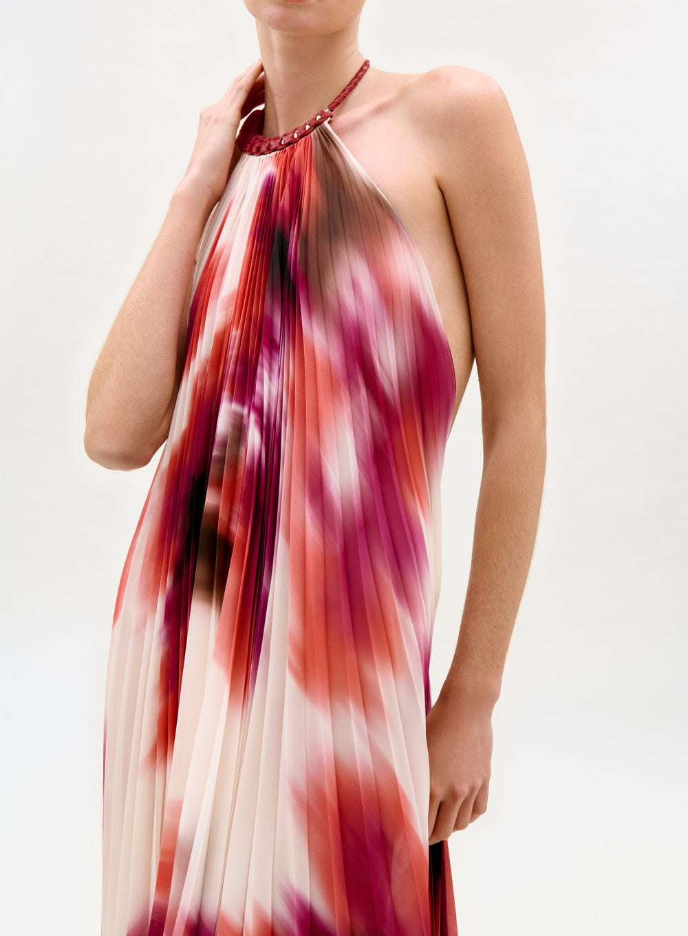 Woman wearing a colorful halter neck dress on a white background