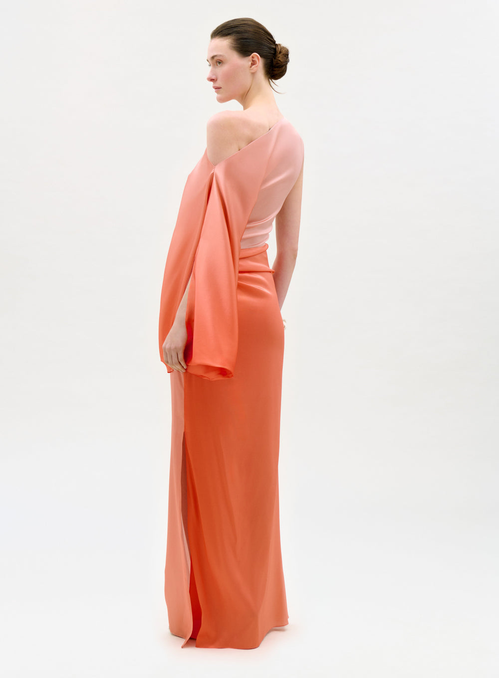 Woman wearing a peach evening gown with a white background