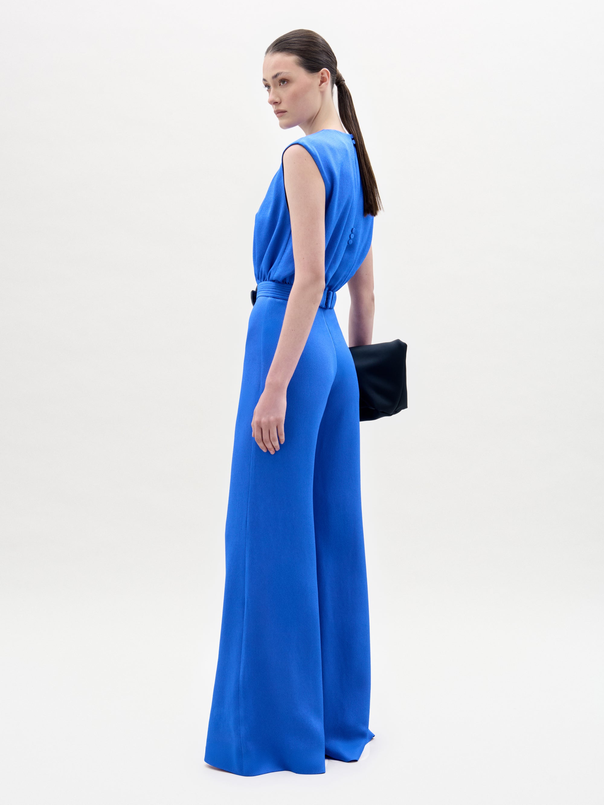 Woman wearing a blue jumpsuit on a white background