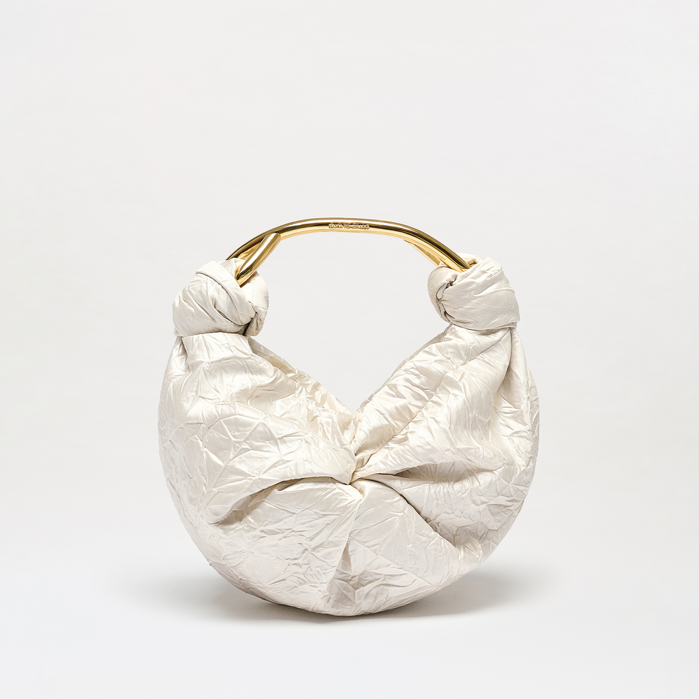 White textured handbag with gold handle on a light gray background