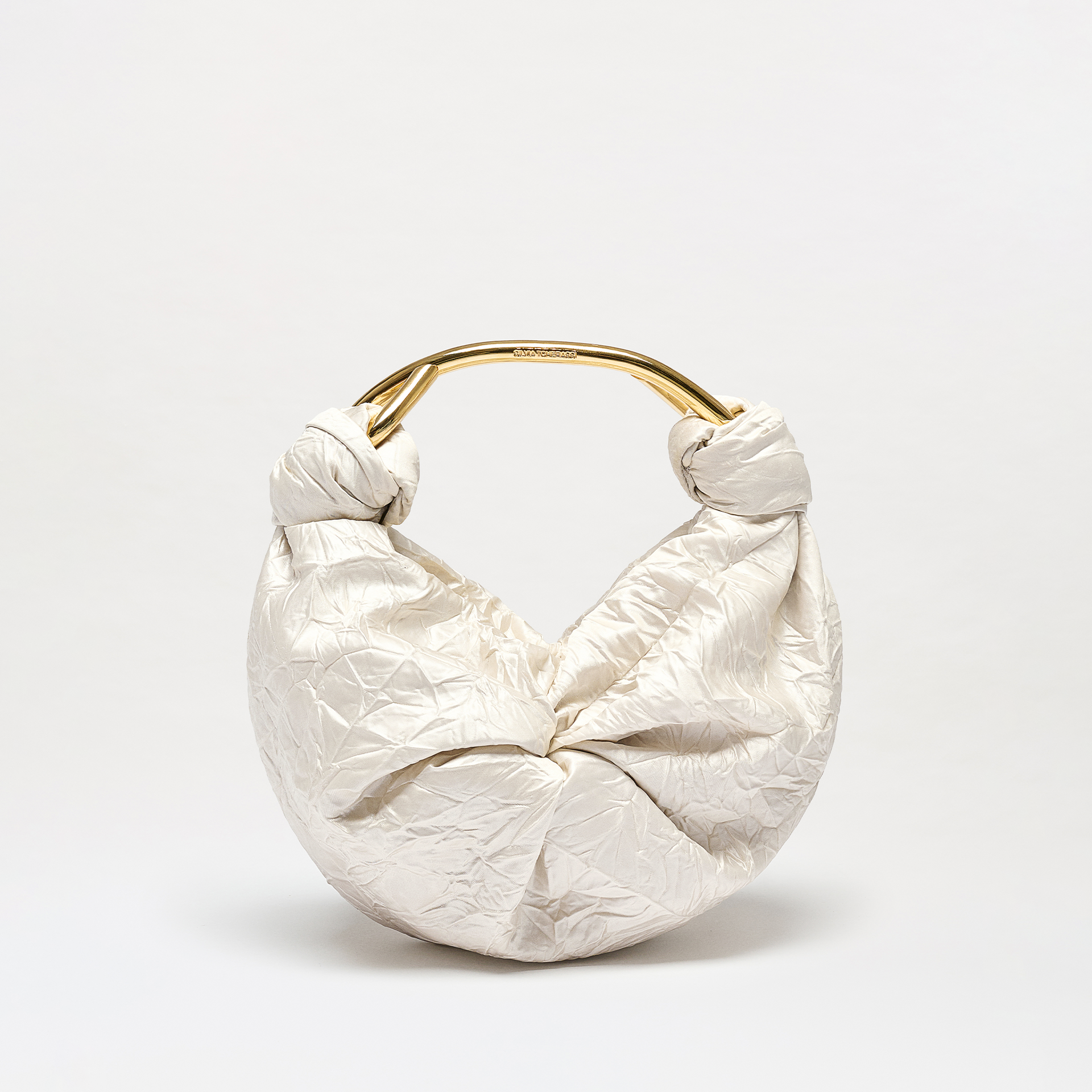 White textured handbag with gold handle on a light gray background