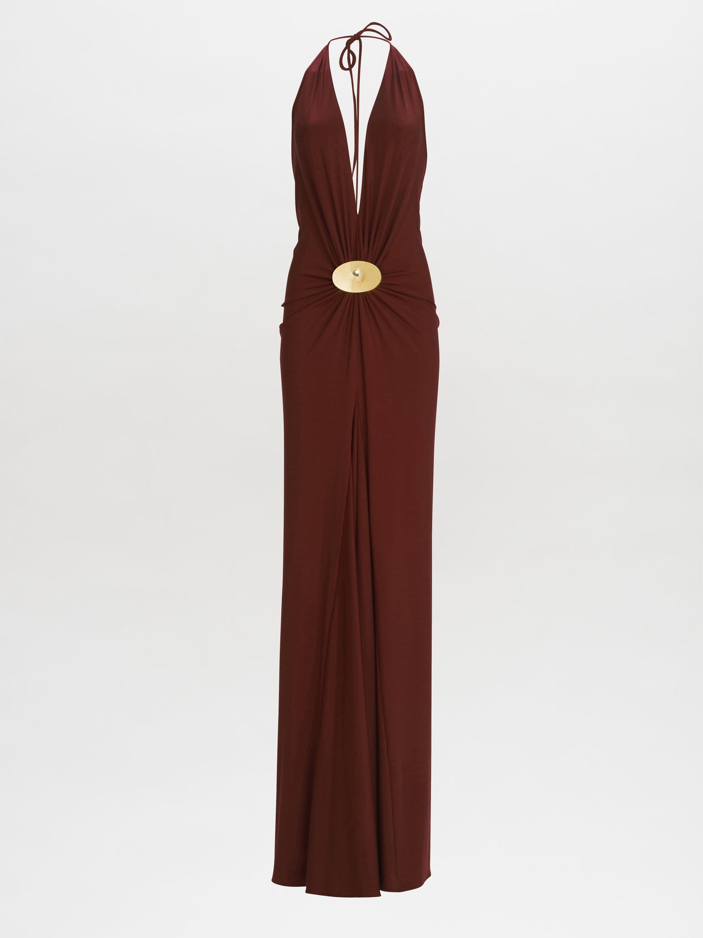 The Aiko Dress by SVT DESIGNS is a long, sleeveless brown Italian maxi dress with a plunging neckline, central waist gathering, and an elegant large round gold embellishment. It features a fitted silhouette that flows gracefully to the floor.