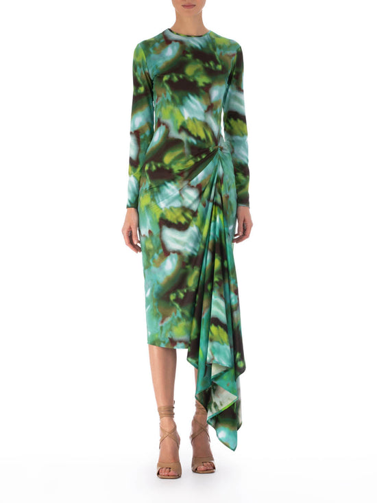 Ananya Dress Juniper Green with a green and blue abstract leaf pattern and asymmetrically draped skirt, isolated on a white background.