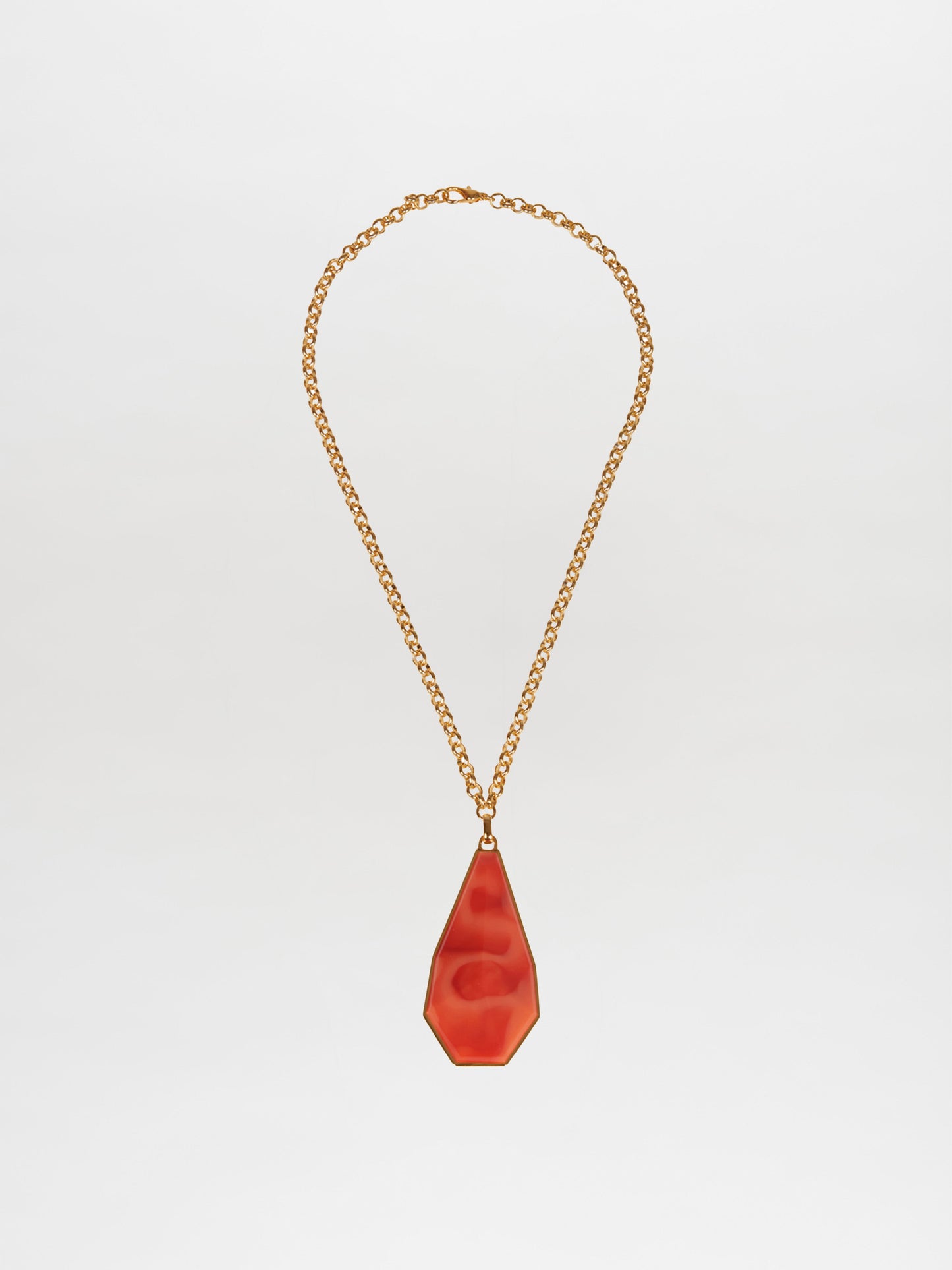 The Ascoli Necklace by Silvia Tcherassi features a gold chain with a smooth red teardrop pendant showcased against a white background, ready to dazzle once ordered.